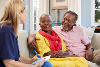 caregiver talking to the elderly couple