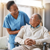 caregiver lookging at the elderly man in a wheelchair