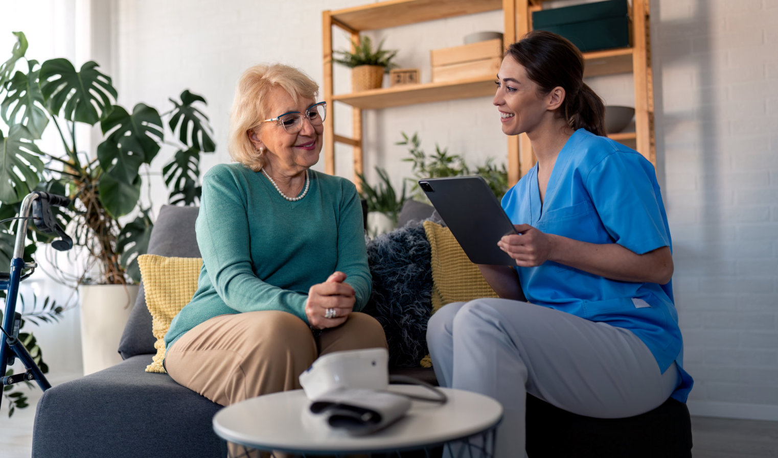 nurse holding a tablet and talking to the senior woman