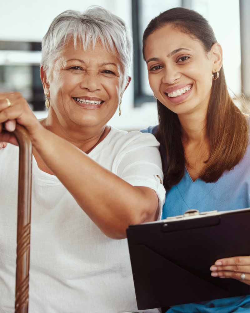 caregiver holding a clipboard and her senior woman patient